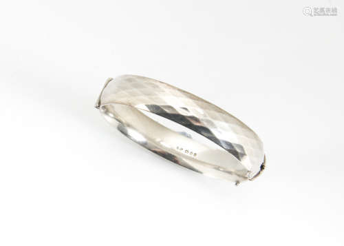 A contemporary heavy silver bangle, hinged clasp with adzed decoration, dated 1964