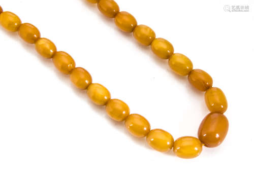 An art deco string of graduated oval amber beads, the strung necklace with replaced silver clasp,