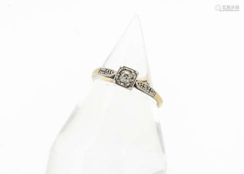 An art deco diamond solitaire ring, platinum set with diamond chip set shoulders on a yellow metal