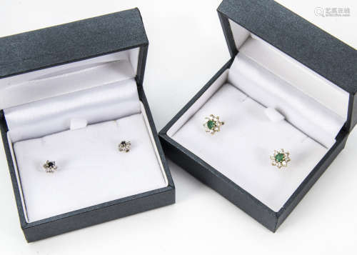 Two pairs of modern gold and gem set stud earrings, including an emerald and diamond pair of
