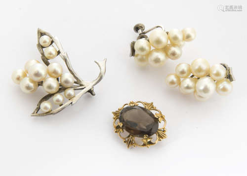 A contemporary smoky quartz and 9ct gold brooch, the oval mixed cut stone in scroll setting, 2.5cm x