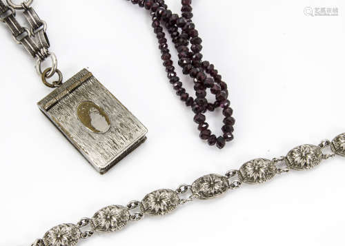 A late Victorian silver plated chain, supporting a silver plated vesta case, together a white