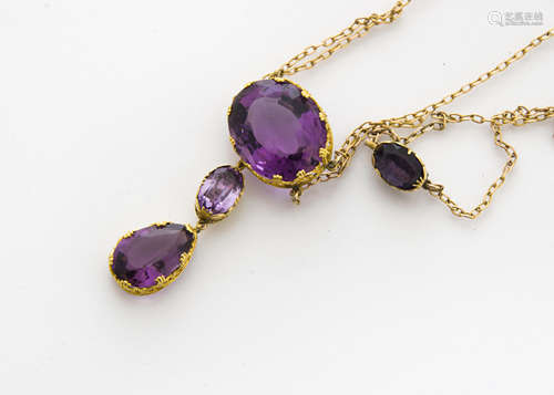 An amethyst necklace and drop pendant, the oval mixed cuts supporting a pear shaped example, total