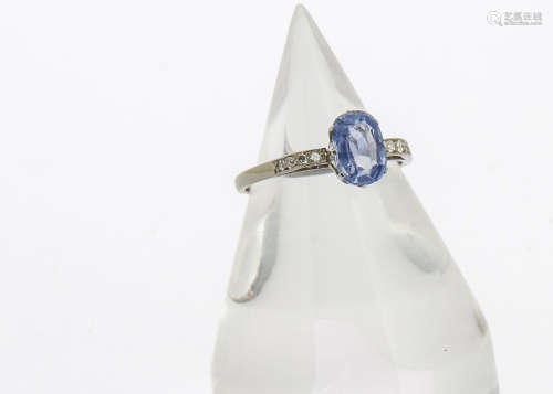 A sapphire and diamond dress ring, the oval cut sapphire in claw setting with diamond set raised