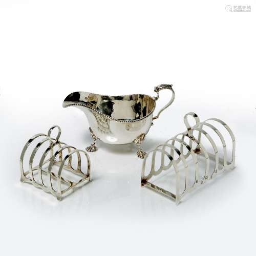 Two silver toast racks of simple form 220 grams, together with a silver sauce boat with gadroon