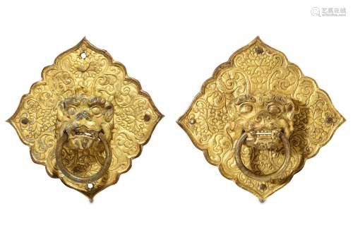 TWO GILT METAL HANDLES. Formed as lion heads with loose rings, mounted on square plates with