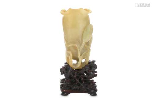 A CHINESE YELLOW JADE 'LOTUS LEAF' VASE. Qing . Formed as a curled leaf issuing from a thick stem