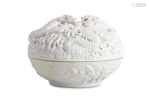 A CHINESE WHITE CIRCULAR BISCUIT 'DRAGON' BOX AND COVER. Qing Dynasty. The cover moulded with two