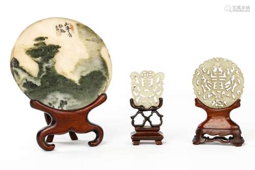 TWO CHINESE JADE PENDANTS AND A CIRCULAR DREAMSTONE PANEL. Qing Dynasty. Wood stands, 11.5cm