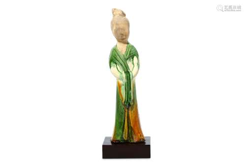 A CHINESE SANCAI-GLAZED POTTERY FIGURE OF A LADY. Tang Dynasty. Standing, wearing long flowing
