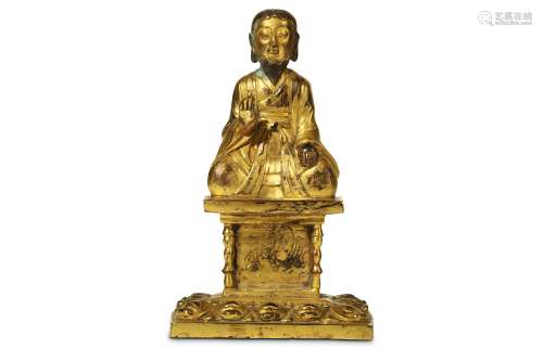 A GILT-BRONZE BUDDHIST FIGURE. Possibly Korean. Seated, wearing monk's robes, with right hand raised