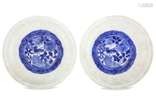 A PAIR OF CHINESE MOULDED BLUE AND WHITE DISHES. Ming Dynasty, Tianqi period. The central roundel
