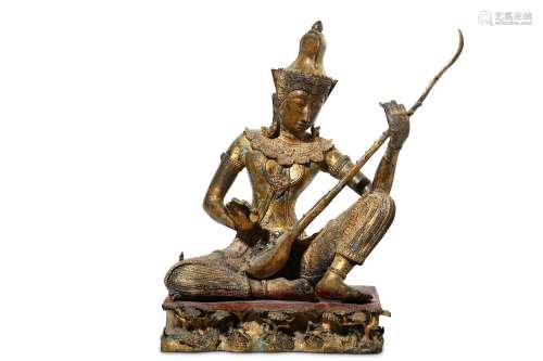 A THAI GILT METAL FIGURE OF A FEMALE MUSICIAN. Seated, wearing ornate trousers, and a tall tiara,
