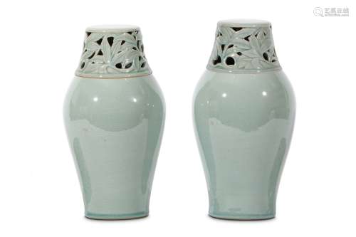 A PAIR OF CELADON JARS AND COVERS. Korea. Rising to wide shoulders with a cover pierced and carved