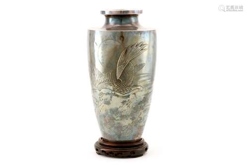 A SILVER VASE. Meiji period. Worked in high relief, uchidashi and katakiribori with an eagle on a