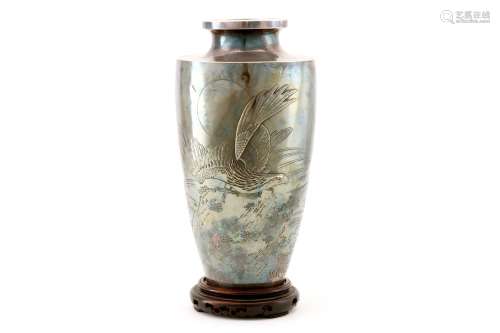 A SILVER VASE. Meiji period. Worked in high relief, uchidashi and katakiribori with an eagle on a