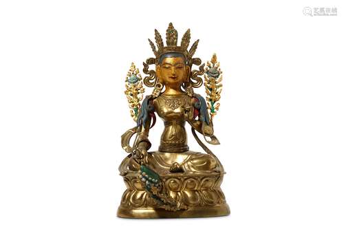 A SINO-TIBETAN GILT METAL FIGURE OF GREEN TARA. Seated in rajalilasana, wearing elaborate jewellery,