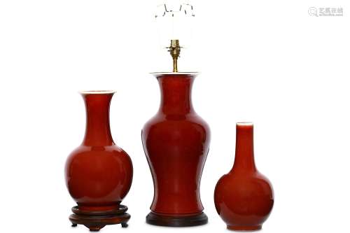THREE CHINESE OX BLOOD-GLAZED VASES. Qing Dynasty. The largest of baluster mounted as a lamp, the