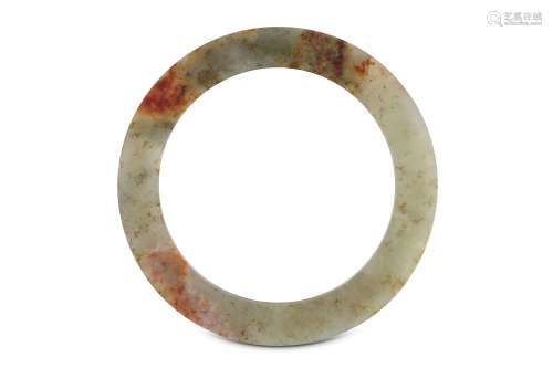 A CHINESE PALE CELADON JADE DISC, BI. Of plain form with a large opening, the stone with russet