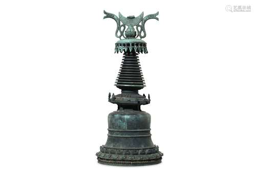 A LARGE BRONZE STUPA. With a bell-shaped base and a double-lotus band to the foot, a  with flame-