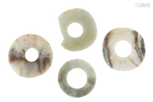 FOUR CHINESE JADE BI DISCS. Comprising two pale celadon discs and two in grey stone with brown and