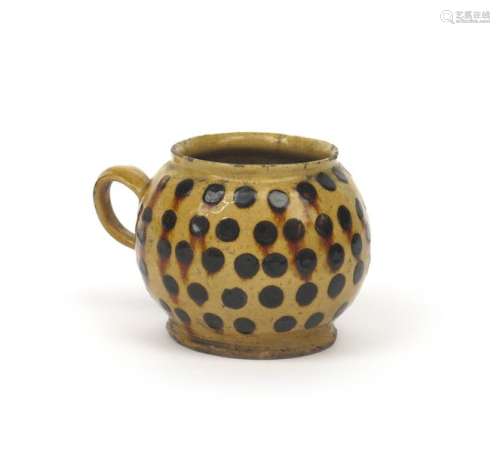 A Staffordshire slipware honey pot c.1700, the glo...;