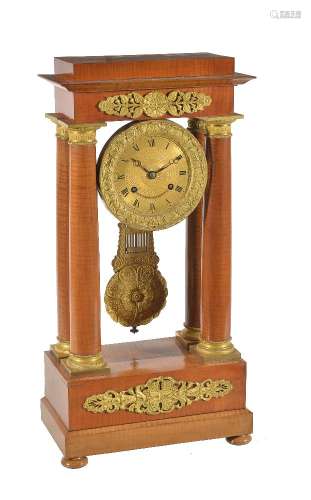 A French Charles X ormolu mounted figured satinwood portico mantel clock