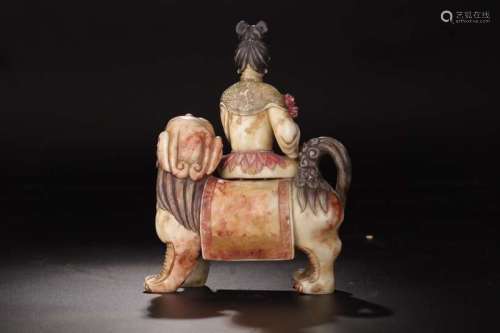 A SOAPSTONE FIGURE OF GUANYIN RIDING A LION