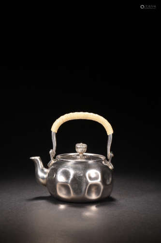 A LOOP-HANDLED SILVER TEAPOT