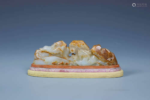 A CHINESE WHITE AND RUSSET JADE DRAGON BRUSH REST