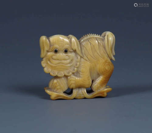 A FINE CARVED BONE  'LION' FAN HOLDER