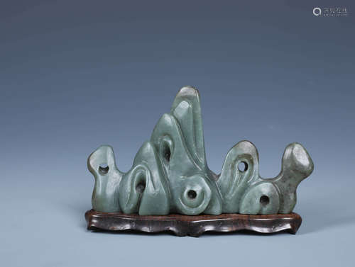 A CARVED CHINESE GREEN JADE MOUNTAIN SHAPED BRUSH REST