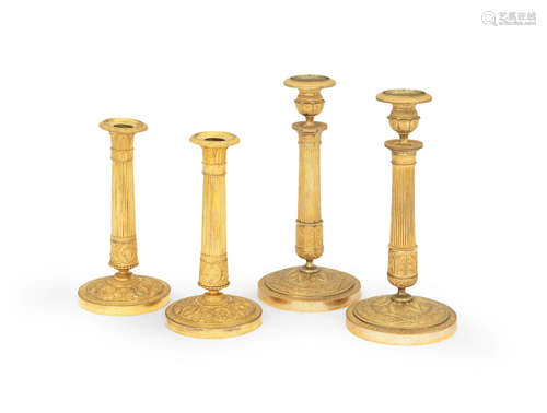 Two pairs of French early 19th century gilt-bronze candlesticks