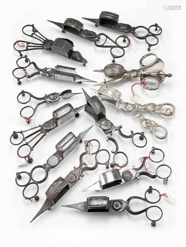 A collection of thirteen candle snuffer and wick trimmers