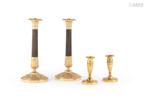 A pair of French gilt and patinated bronze candlesticks in the Empire style