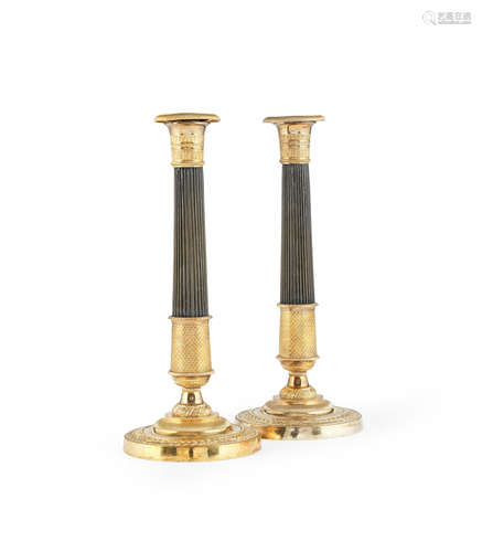 A pair of French gilt and patinated bronze candlesticks