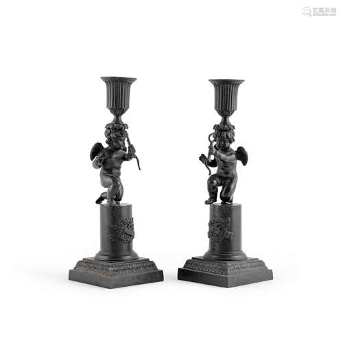 A pair of 19th century patinated iron candlesticks