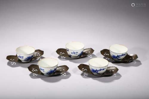 A SET OF FIVE BLUE AND WHITE CUPS WITH SILVER HOLDERS