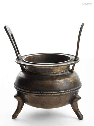 A BRONZE TWO-HANDLED TRIPOD CENSER