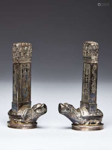 A PAIR OF SILVER TURTLE SUPPORTED STELES