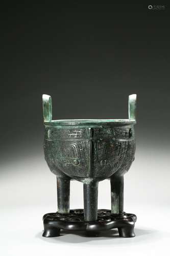 A BRONZE 'TAOTIE' TRIPOD DING VESSEL AND STAND