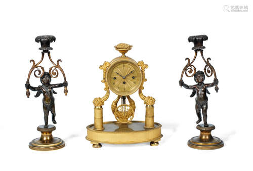 A 19th century French gilt bronze mantel clock with pull repeat together with a pair of patinated and gilt bronze figural candlesticks