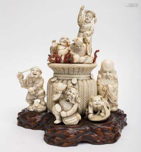 Rare group of okimono Ivory and coral on a boxwood stand carved as a boulder, representing the