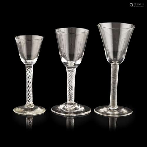 THREE GEORGIAN WINE GLASSESMID-18TH CENTURY all with round funnel bowls and slightly conical feet,