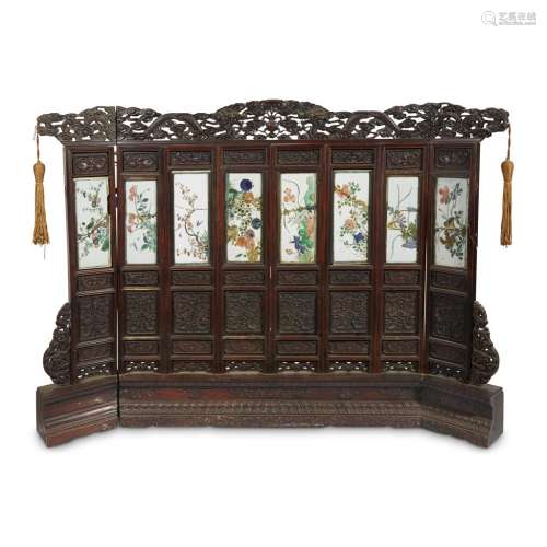 A Chinese eight panel porcelain and carved hardwood table screen
