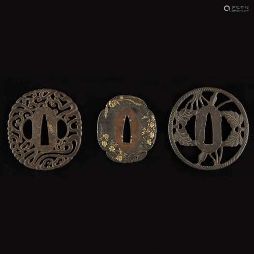 Two Japanese pierced iron tsuba and a gold-inlaid patinated metal tsuba