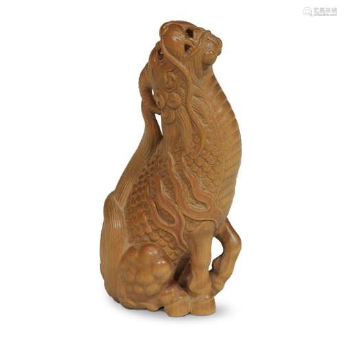 A Japanese carved boxwood netsuke of a seated kirin, Risshisai Kangyoku