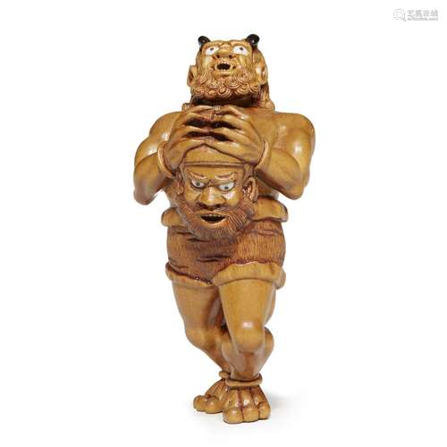 A Japanese carved boxwood netsuke depicting an oni with Shoki mask, Kosei Hideyuki