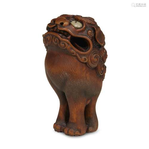 A Japanese carved dark wood netsuke of a shishi