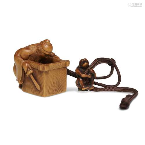 A humorous Japanese carved boxwood netsuke, Shoki gazing down a well